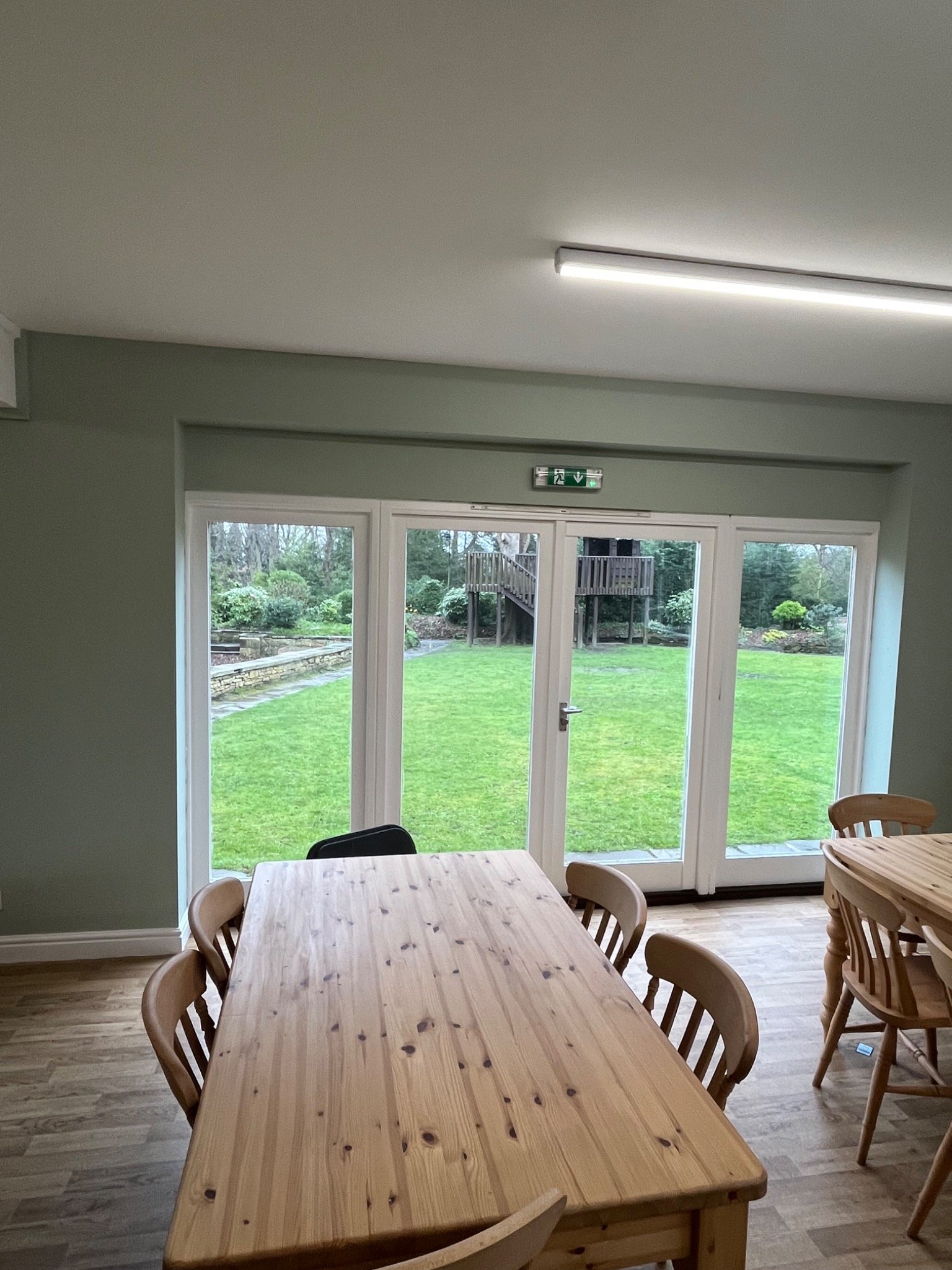 Dining area with large timber table and garden outlook