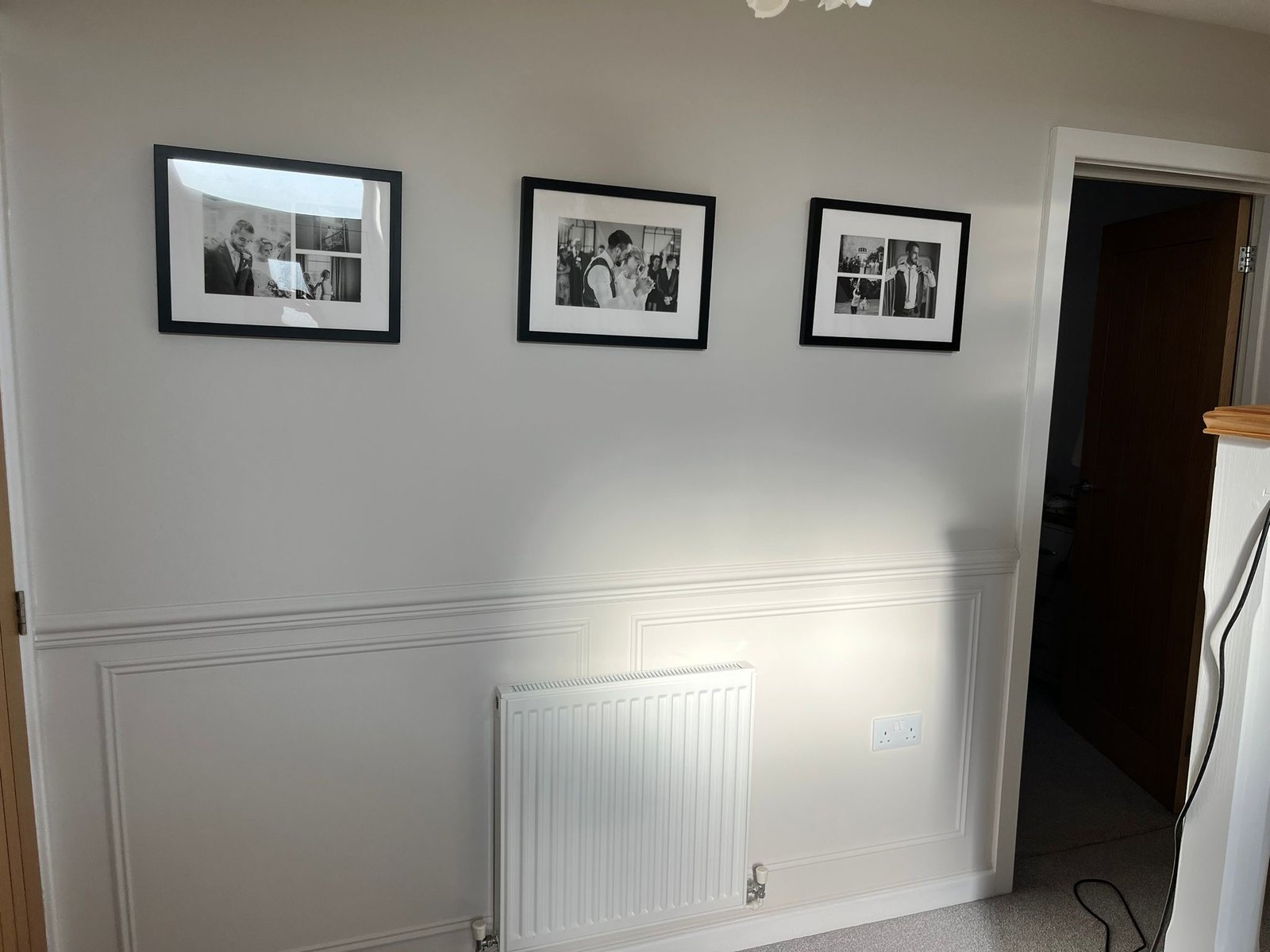 Freshly painted feature wall with framed artwork and decorative trim